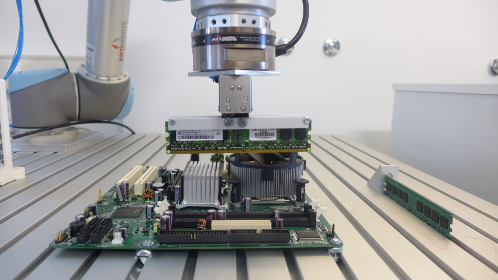 Robot placing a RAM module on a mainboard